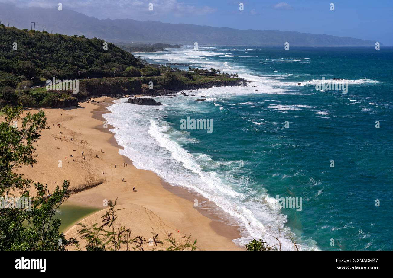 High above Waimea Bay Beach: The beautiful beach and beach park at Wiamea Bay. Large waves and red flags keep pepole out of the water, but lots are there to watch. Stock Photo