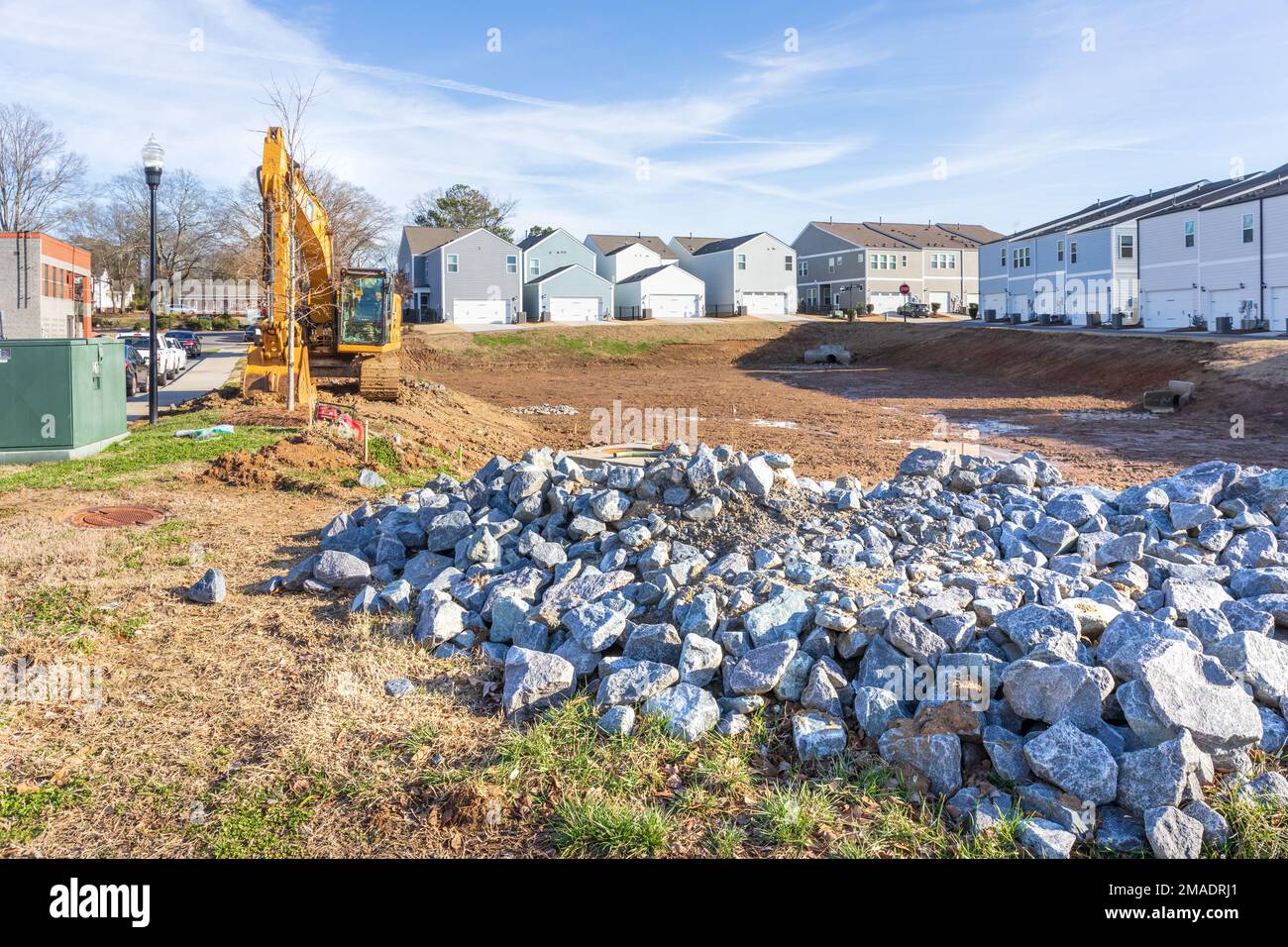 PINEVILLE, NC, USA-15 JANUARY 2023: Construction site in downtown with two backhoe tractors. Sunny, blue sky day. Stock Photo