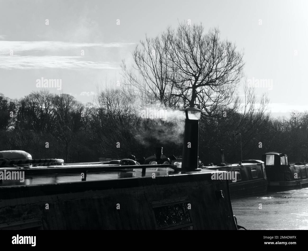 Narrowboats with smoke on a winter morning Aynho Oxfordshire black and white Stock Photo