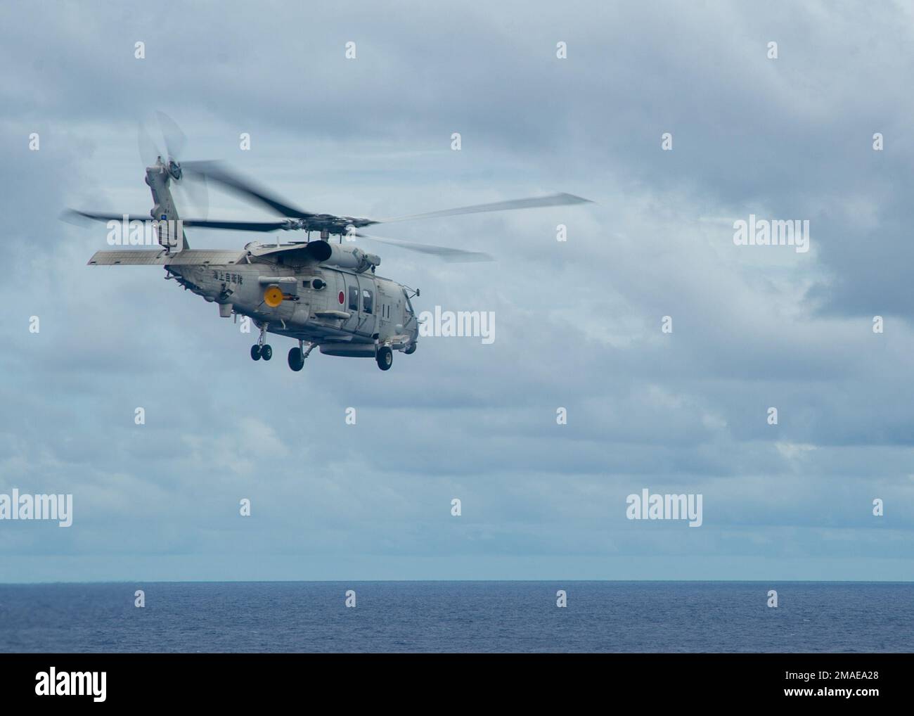 220526-N-YQ181-2046 PHILIPPINE SEA (May 26, 2022) A Japan Maritime Self-Defense Force (JMSDF) SH-60K Sea Hawk helicopter attached to the JMSDF destroyer JS Teruzuki (DDG 116) departs from the flight deck of U.S. Navy’s only forward-deployed aircraft carrier USS Ronald Reagan (CVN 76). The U.S. Navy and JMSDF have worked together as maritime partners for more than 60 years supporting the U.S.-Japan alliance. Ronald Reagan, the flagship of Carrier Strike Group 5, provides a combat-ready force that protects and defends the United States, and supports alliances, partnerships and collective maritim Stock Photo
