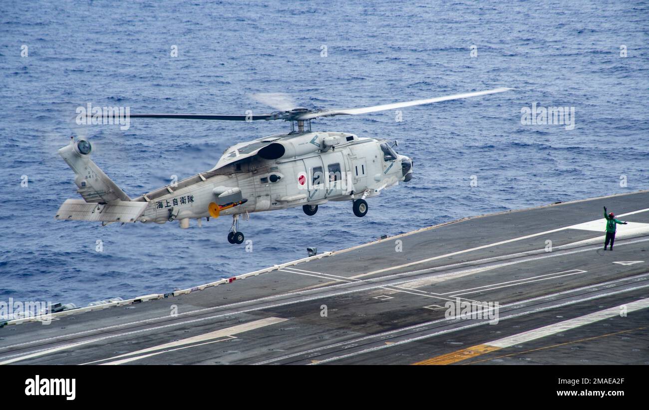 220526-N-YQ181-2019 PHILIPPINE SEA (May 26, 2022) A Japan Maritime Self-Defense Force (JMSDF) SH-60K Sea Hawk helicopter attached to the JMSDF destroyer JS Teruzuki (DDG 116) lands aboard the U.S. Navy’s only forward-deployed aircraft carrier USS Ronald Reagan (CVN 76). The U.S. Navy and JMSDF have worked together as maritime partners for more than 60 years supporting the U.S.-Japan alliance. Ronald Reagan, the flagship of Carrier Strike Group 5, provides a combat-ready force that protects and defends the United States, and supports alliances, partnerships and collective maritime interests in Stock Photo