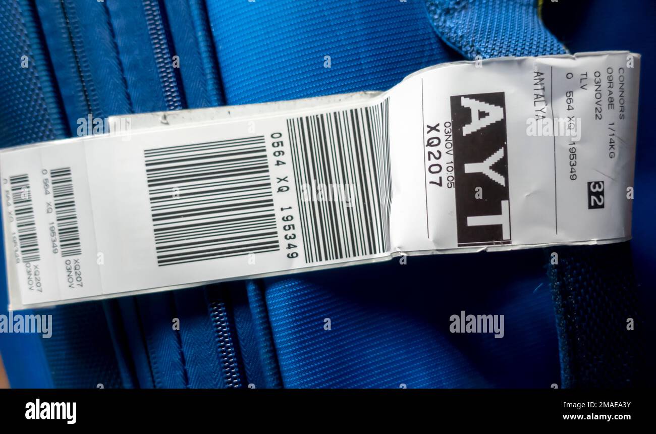 A suitcase with an airline baggage tag shows the three letter airport code for AYT - Antalya Airport Stock Photo