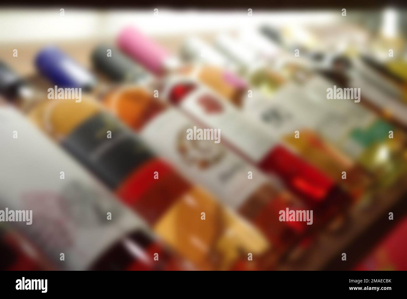 Blurred liquor store aisle wine rack whisky champagne bottles lying on