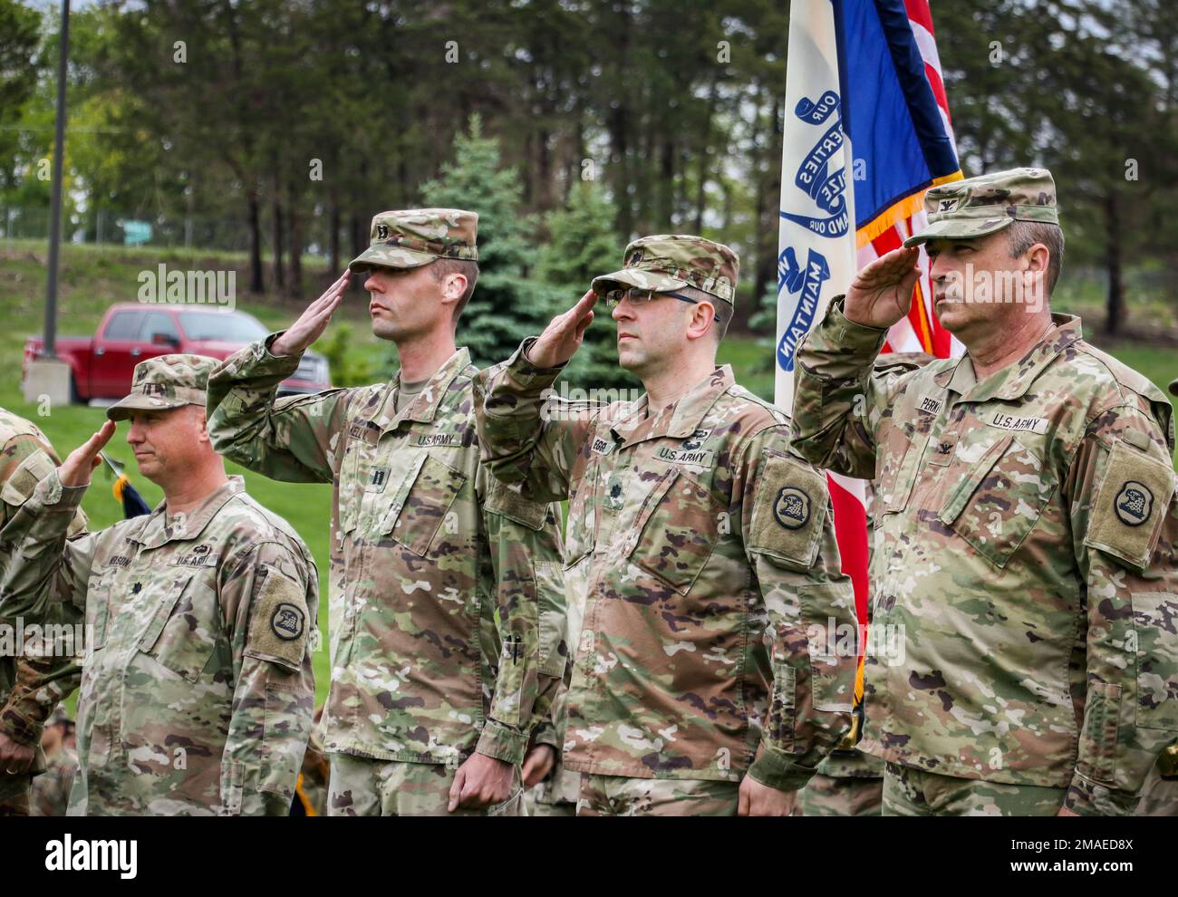 Iowa National Guard Soldiers salute as reveille is played during an