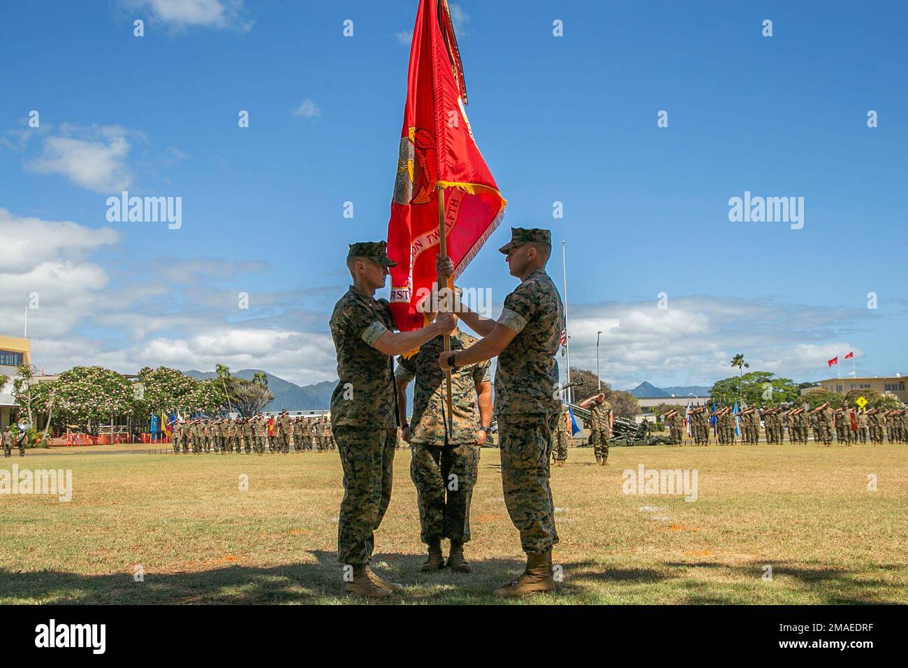 U.S. Marine Corps Lt. Col. Richard Neikirk, outgoing commanding officer, 1st Battalion, 12th Marine Regiment, passes the colors to Lt. Col. Joseph Gill II, incoming commanding officer, during the unit’s change of command ceremony on Marine Corps Base Hawaii, May 26, 2022. This tradition represents the passing of command from one leader to another. Stock Photo