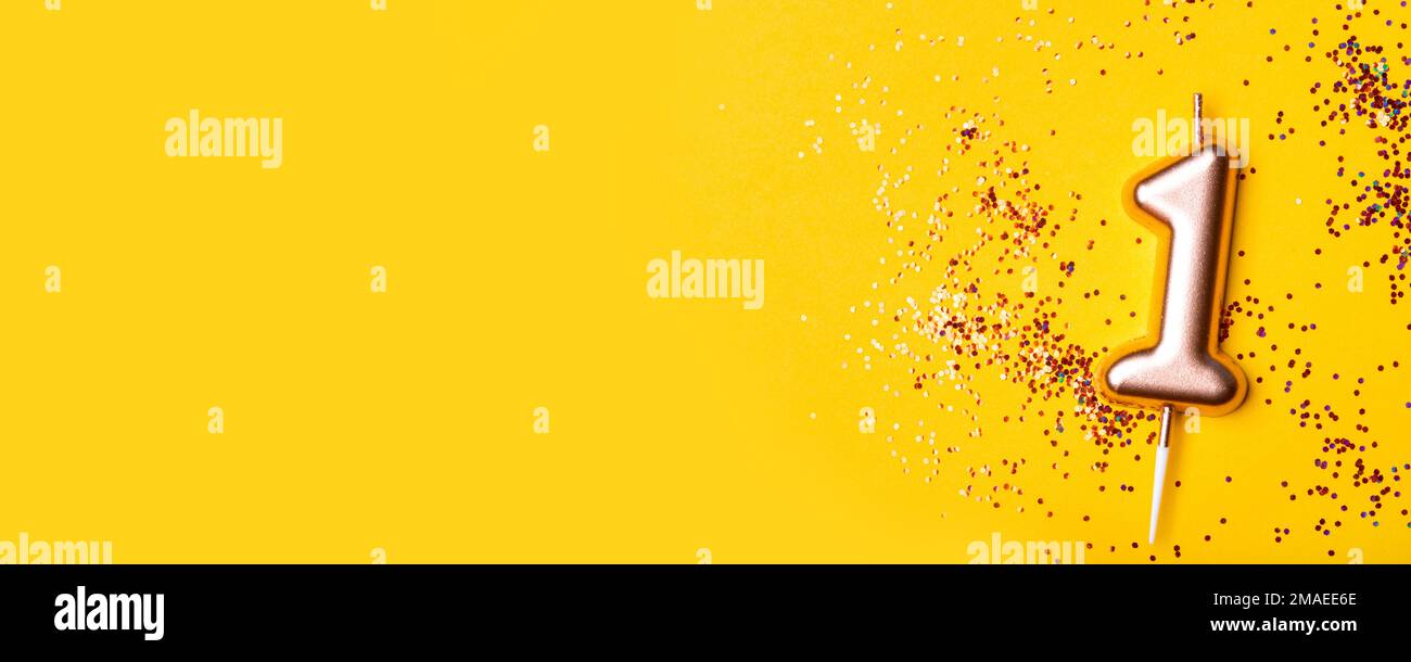 Gold candle in the form of number one. Stock Photo
