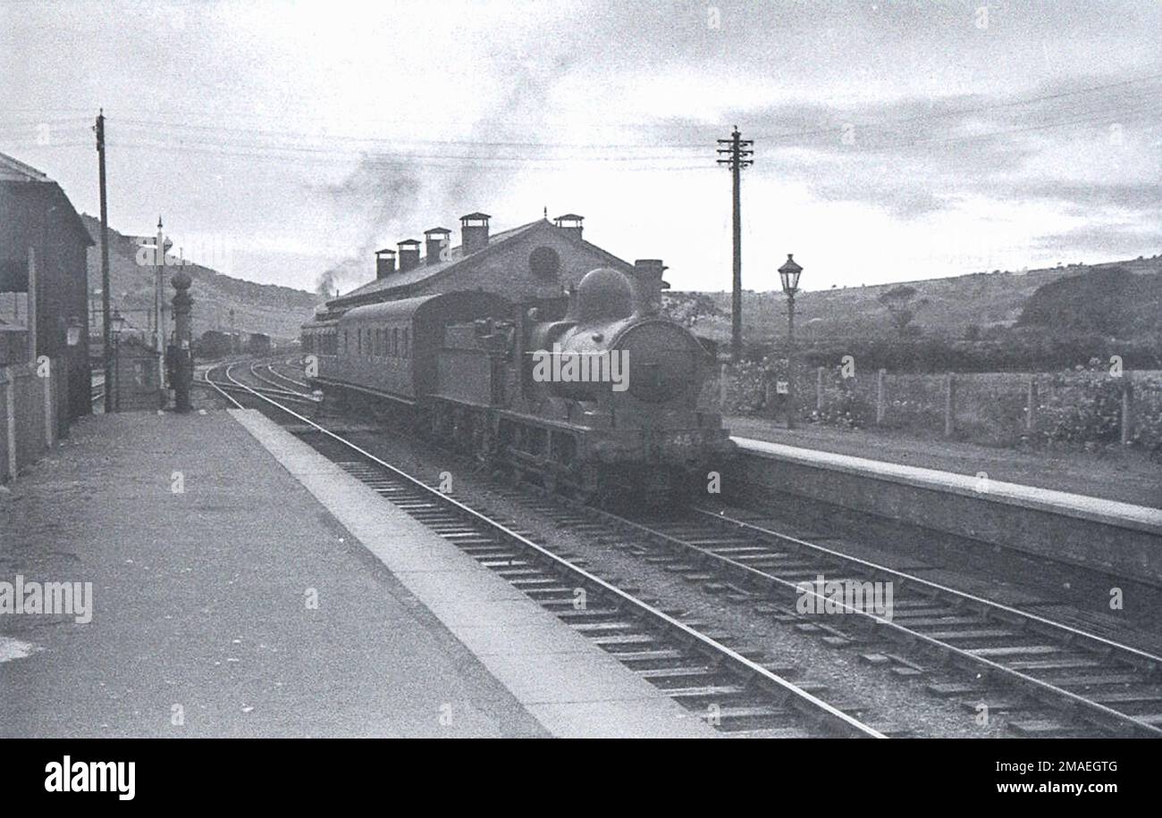 GWR 'Dean Goods' 0-6-0 No.2450 on a 2-coach train including a Clerestory coach at Portmadoc station in the 1930s Stock Photo