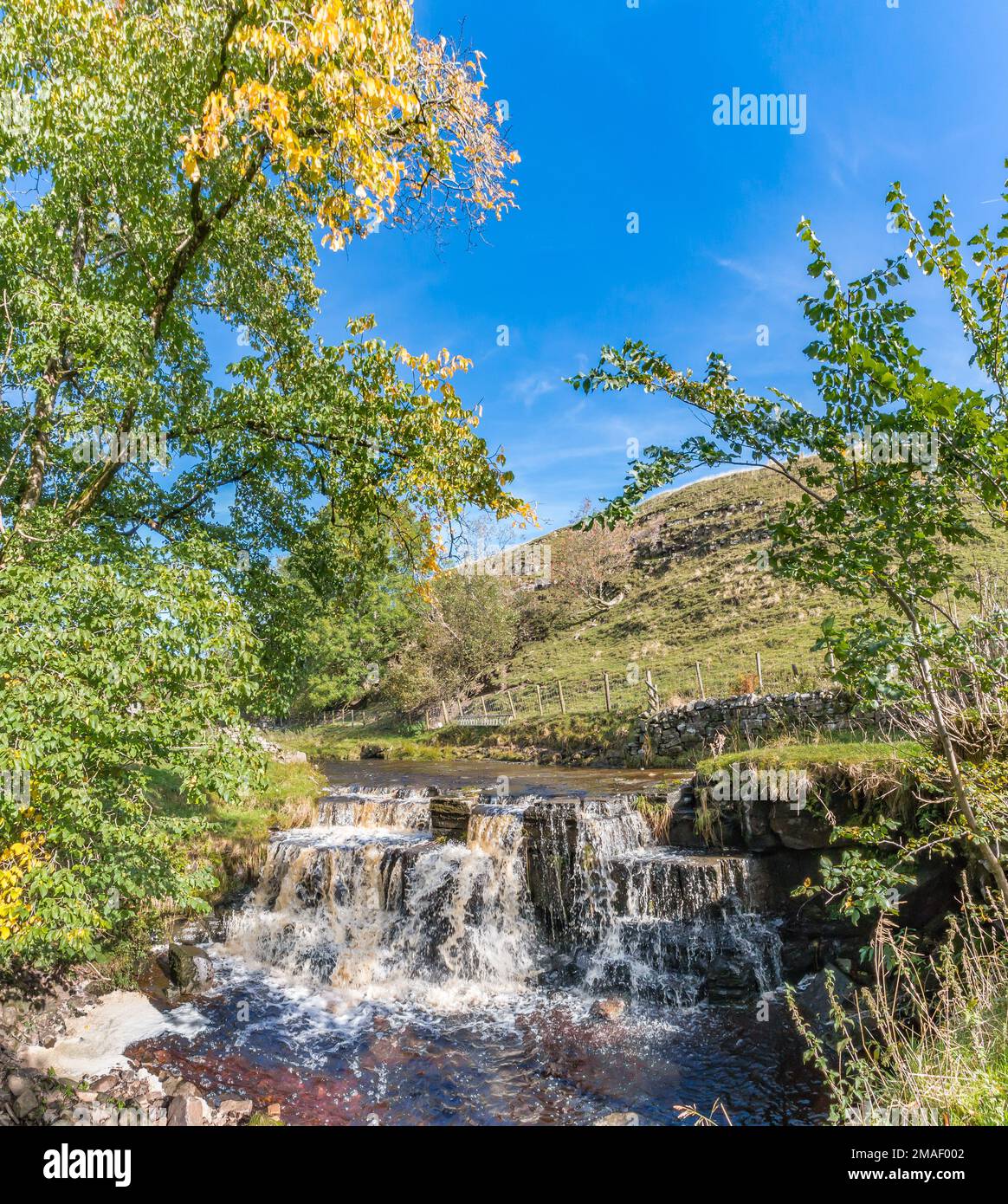 Ettersgill Beck swollen by heavy rainfall a couple of days earlier brings this waterfall back to life in strong autumn sunshine. Stock Photo