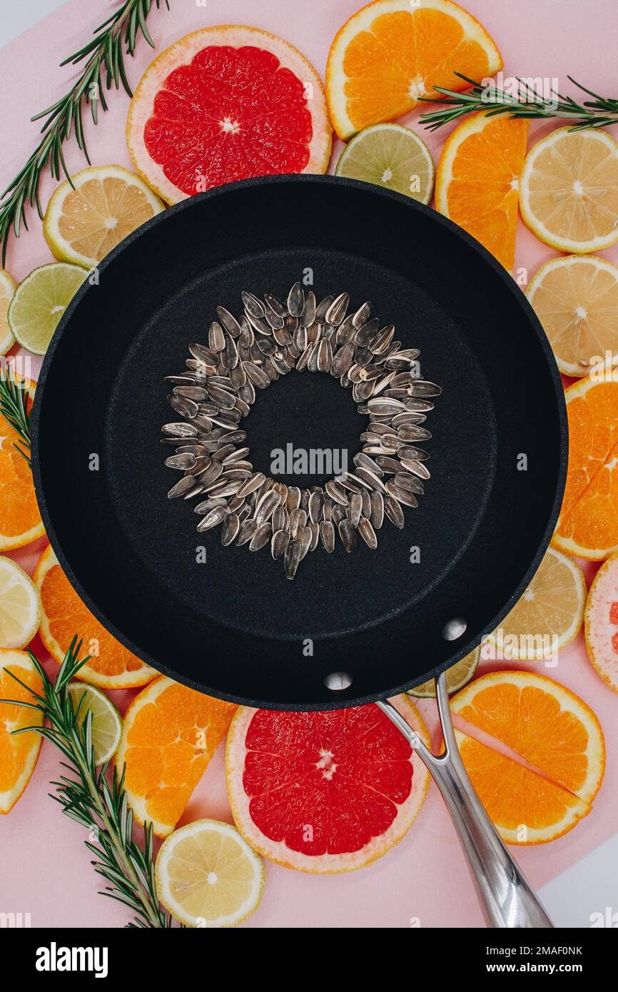 black frying pan with sunflower seeds, from which a sunflower flower is