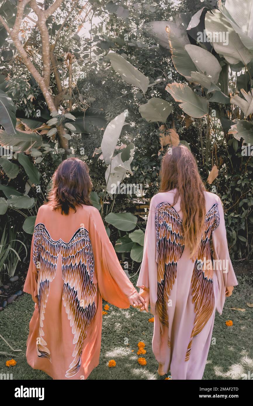 A vertical shot of two pretty girls holding hands in a garden Stock ...