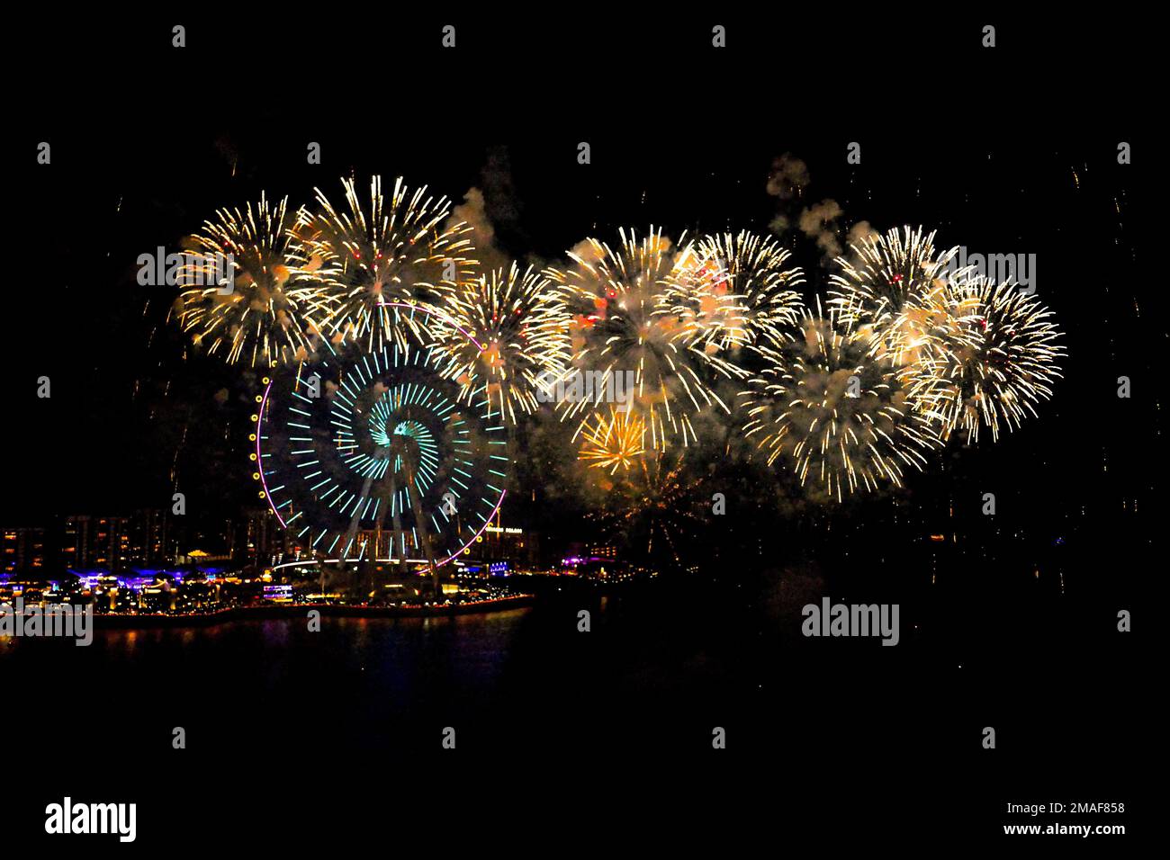 Bright fireworks in front of the Dubai Wheel overlooking the Persian Gulf on New Year's Eve Stock Photo
