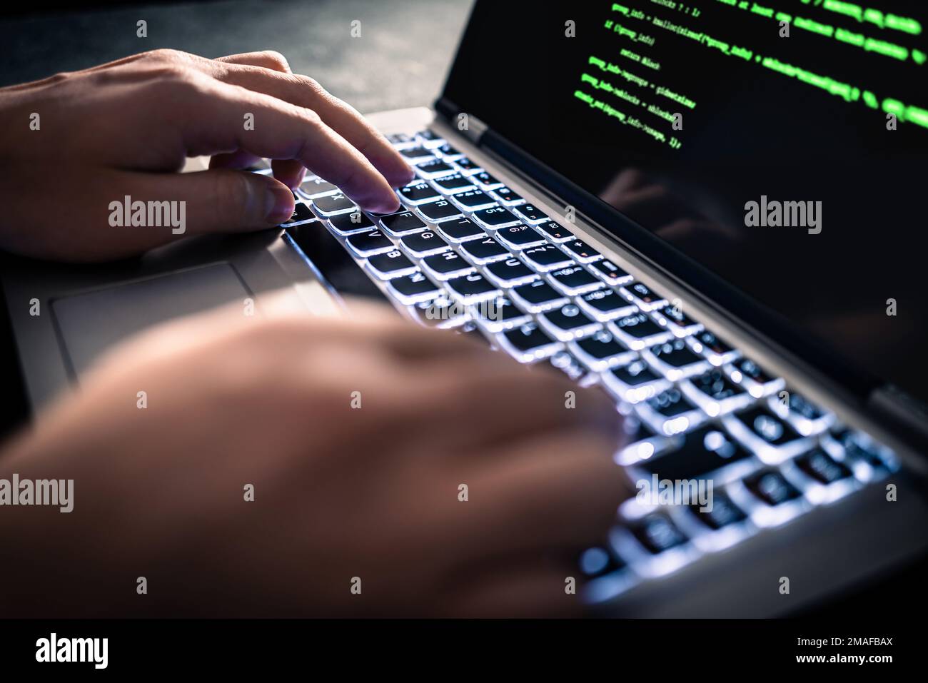 Hacker with malware software code in computer screen. Developing fraud website. Cybersecurity attack and web crime with laptop. Cyber security. Stock Photo