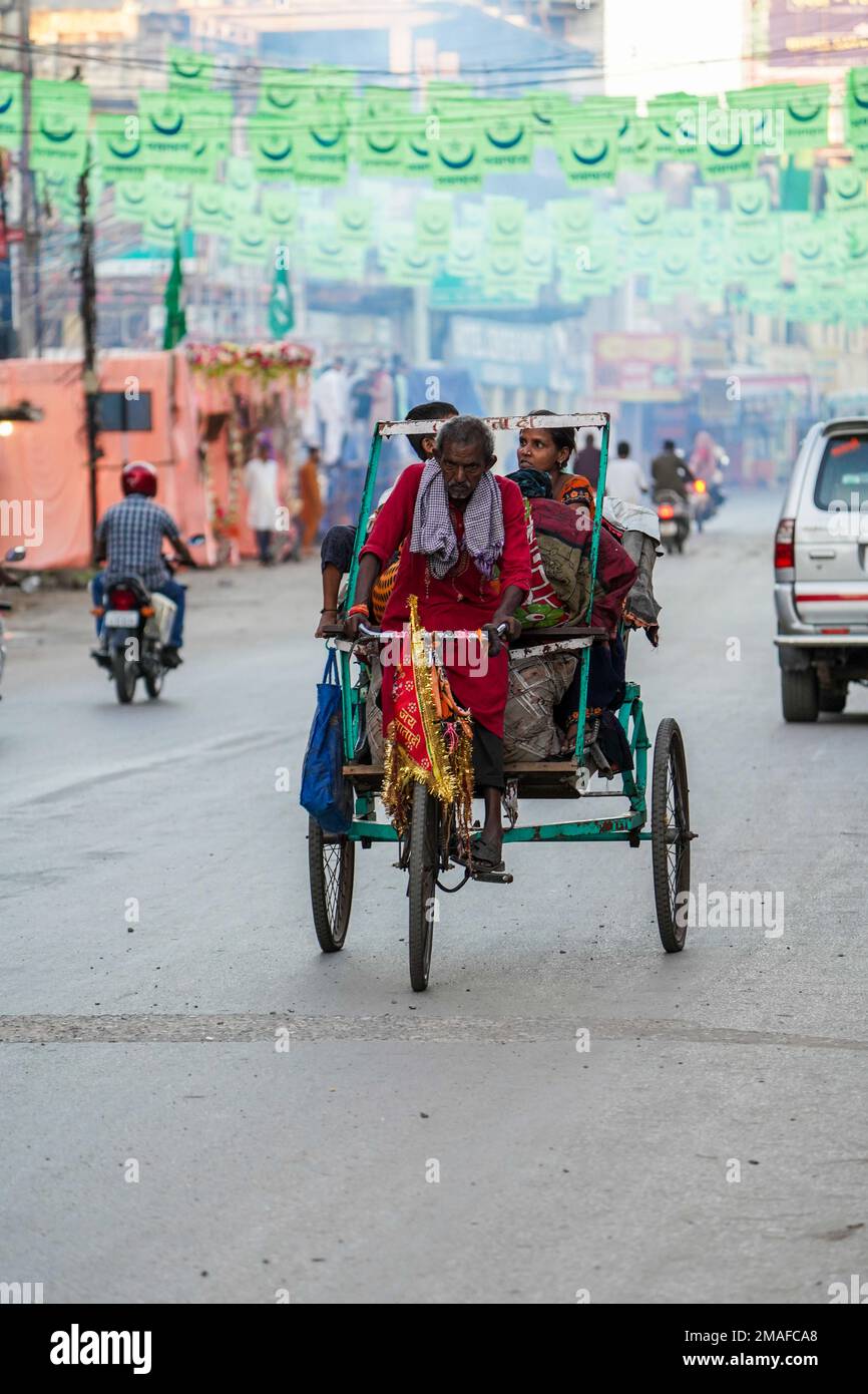 January, 2022, Raipur, chhattisgarh, Indian Old man carrying passengers pulling rickshaw, a bicycle taxi carrying passengers in raipur city capital of Stock Photo