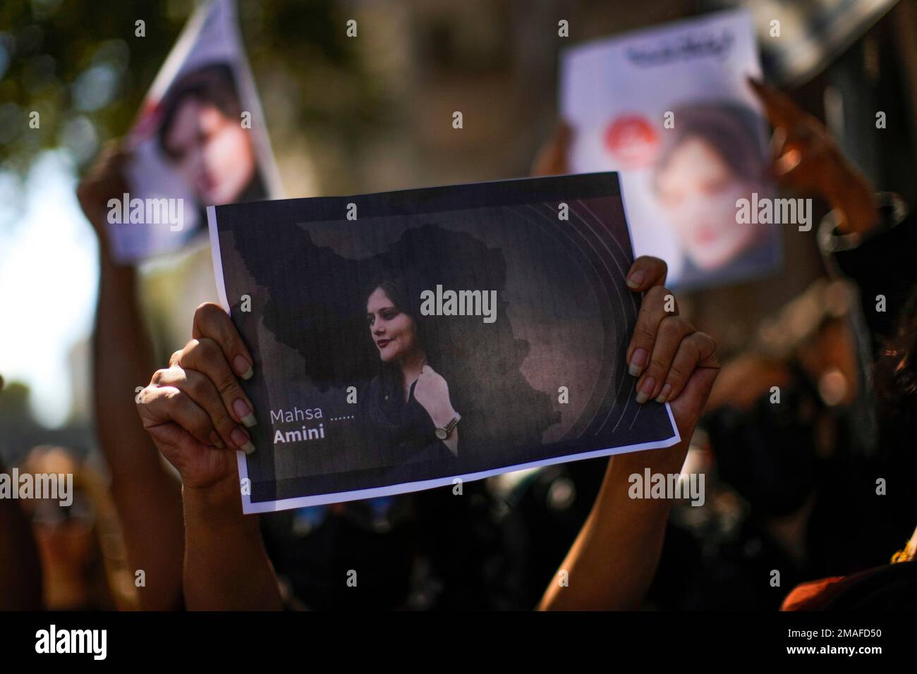 A woman holds a a photo of Iranian Mahsa Amini during a protest against ...