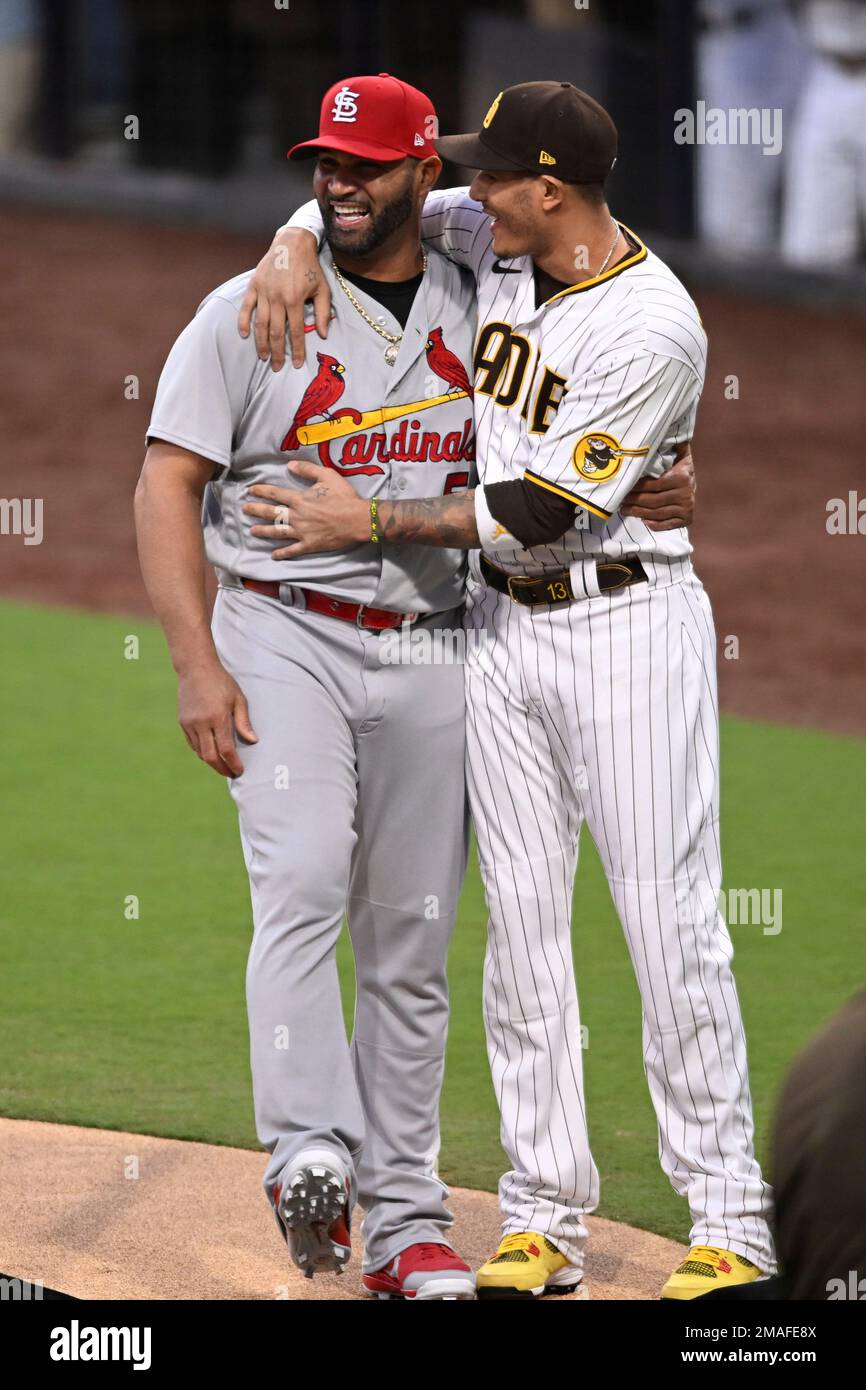 St. Louis Cardinals designated hitter Albert Pujols, left, jokes with San  Diego Padres third baseman Manny Machado after he was presented with a  surfboard from the Padres to honor his future retirement