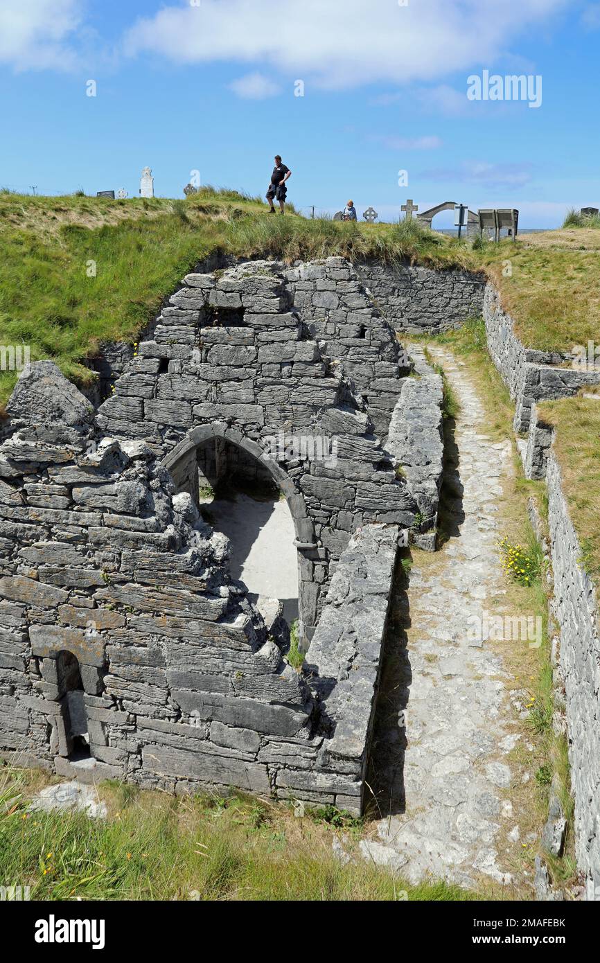 Visitors at the Sunken Church of Inis Oirr in Ireland Stock Photo