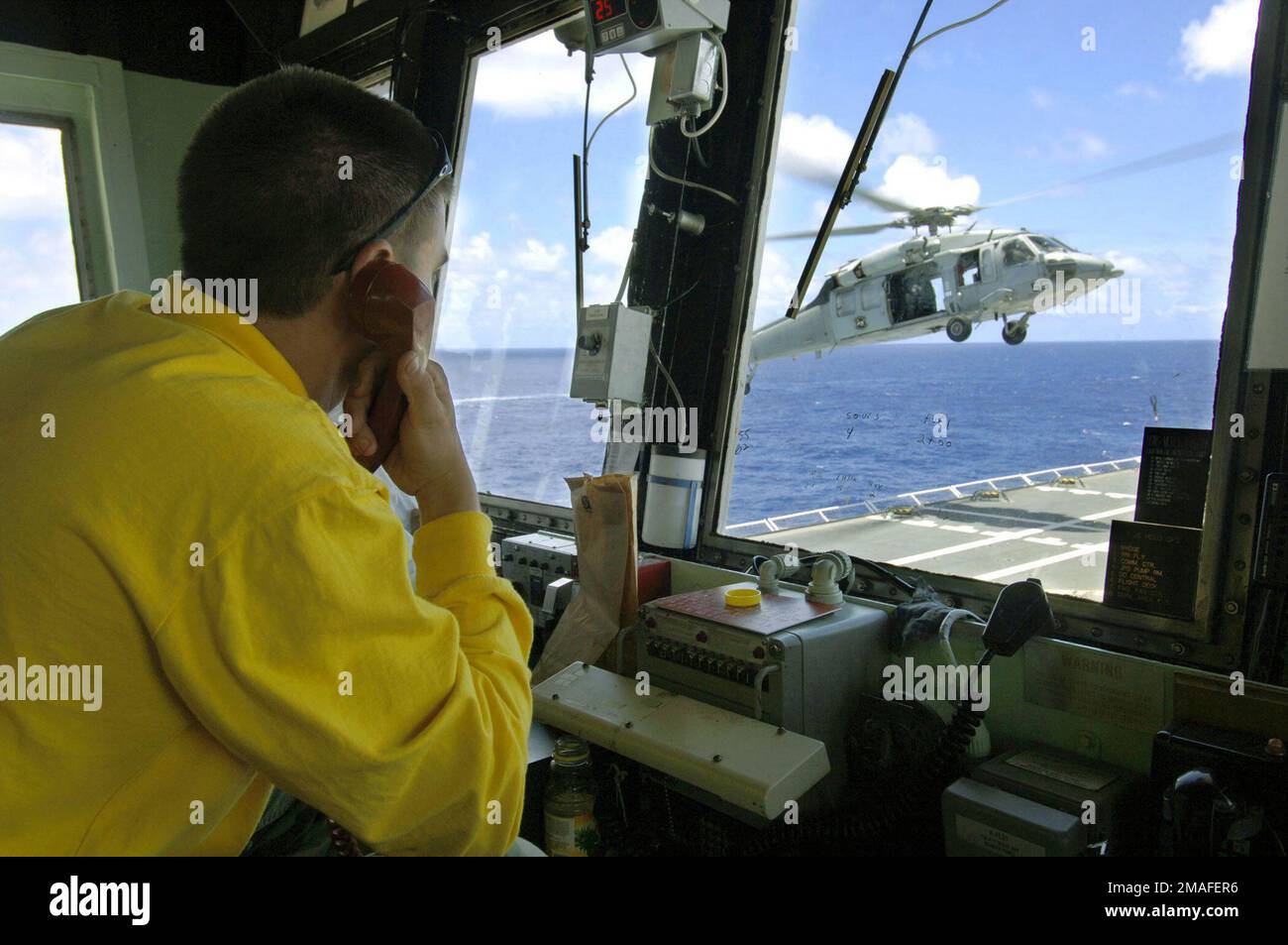 060514-N-6501M-002. [Complete] Scene Caption: US Navy (USN) Aviation Boatswain's Mate Second Class (AB2) Zachary L. Dabney monitors the arrival of aUSN MH-60S Sea Hawk helicopter, assigned to Helicopter Sea Combat Squadron 25 (HSC-25), as it delivers supplies to the flight deck aboard the USN Military Sealift Command (MSC), Hospital Ship, USNS MERCY (T-AH 19), during a Replenishment at Sea (RAS) evolution with the USN MSC Mars Class: Combat Stores Ship, USNS CONCORD (T- AFS 5). The USNS MERCY is currently underway in the Pacific Ocean, conducting a scheduled five-month deployment to deliver ai Stock Photo