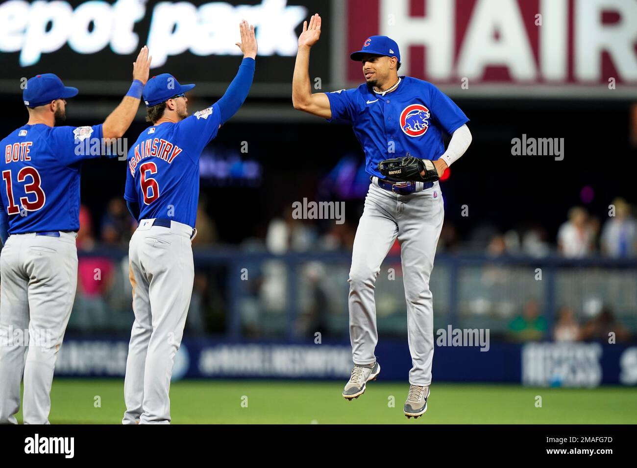 Chicago Cubs third baseman David Bote (13), shortstop Zach McKinstry (6)  and right fielder Nelson Velazquez celebrate the team's 2-1 win in a  baseball game against the Miami Marlins, Tuesday, Sept. 20