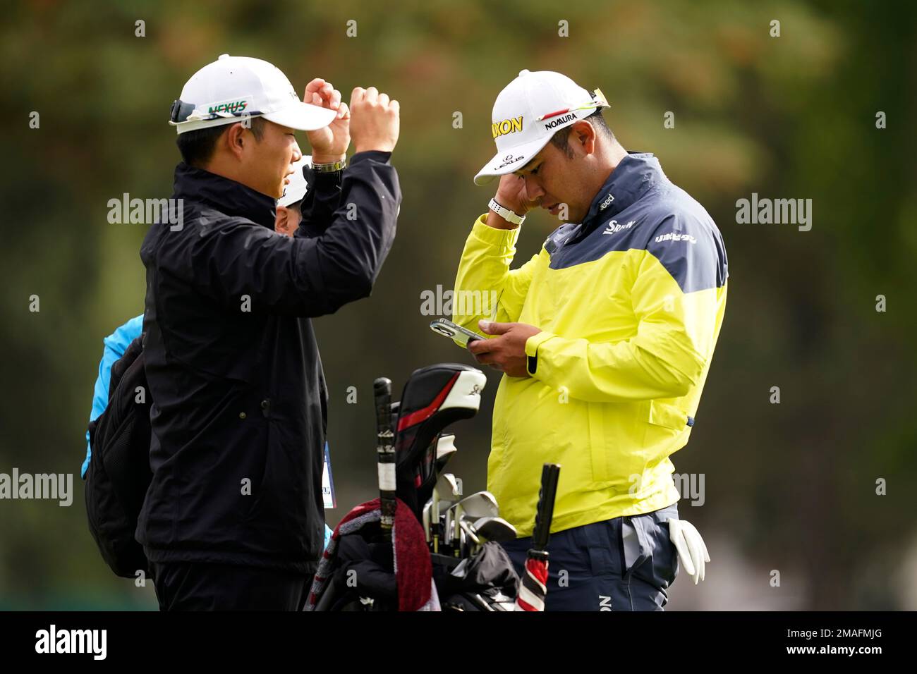 Hideki Matsuyama, of Japan, reads his phone while on the putting green