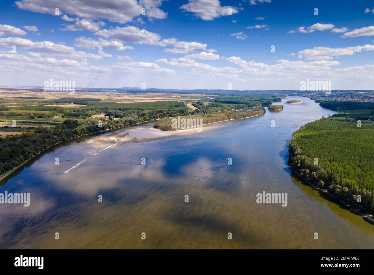 An aerial view of a river with with lush green vegetation on both sides ...