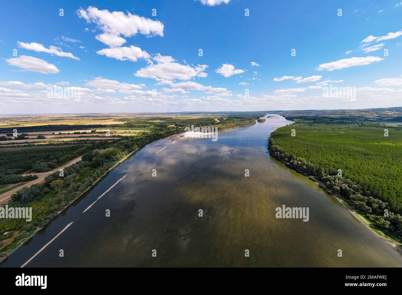 An aerial view of a river with with lush green vegetation on both sides ...