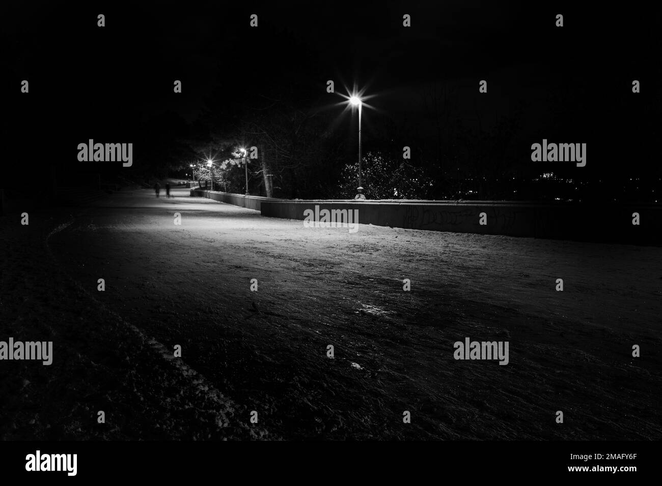 An empty road illuminated by street lights at night Stock Photo Alamy