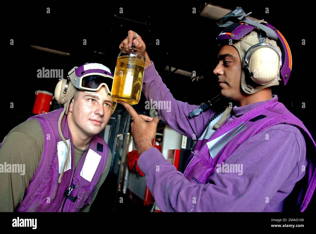 060813-N-5914D-006. [Complete] Scene Caption: 060813-N-5914D-006 (Aug. 13, 2006)US Navy (USN) Aviation Boatswain's Mate Fuels Third Class Rahim Panjwani (right) and US Marine Corps (USMC) Lance CPL. Gene Palmer, Bulk Fueler, Marine Medium Helicopter Squaron 165 (HMM-165) Reinforced (REIN), 15th Marine Expeditionary Unit (MEU), inspect the purity of jet fuel that will be used by aircraft aboard the USN Wasp Class Amphibious Assault Ship (LHD) USS BOXER (LHD 4). The 15th MEU and the BOXER are part of Expeditionary Strike Group 5 (ESG-5) which is currently participating in their Joint Task Force Stock Photo