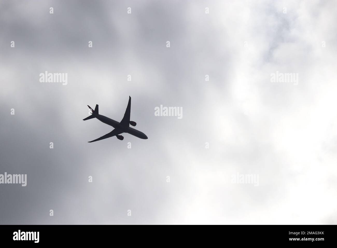 Airplane silhouette on storm sky background. Commercial plane taking