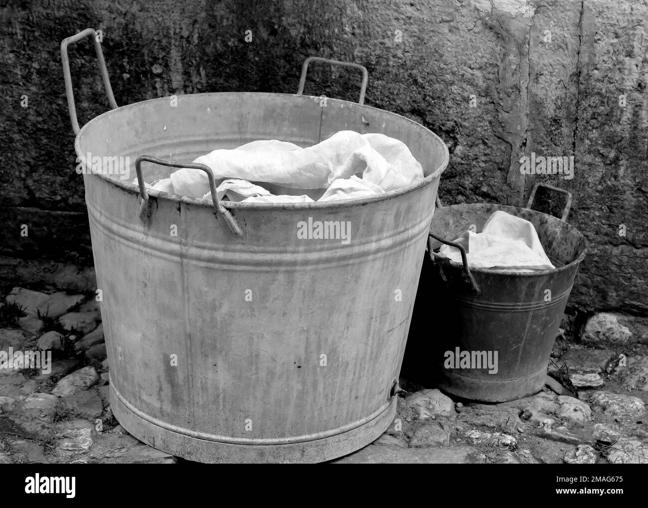 tub for doing laundry and a small bucket with clean and laundered