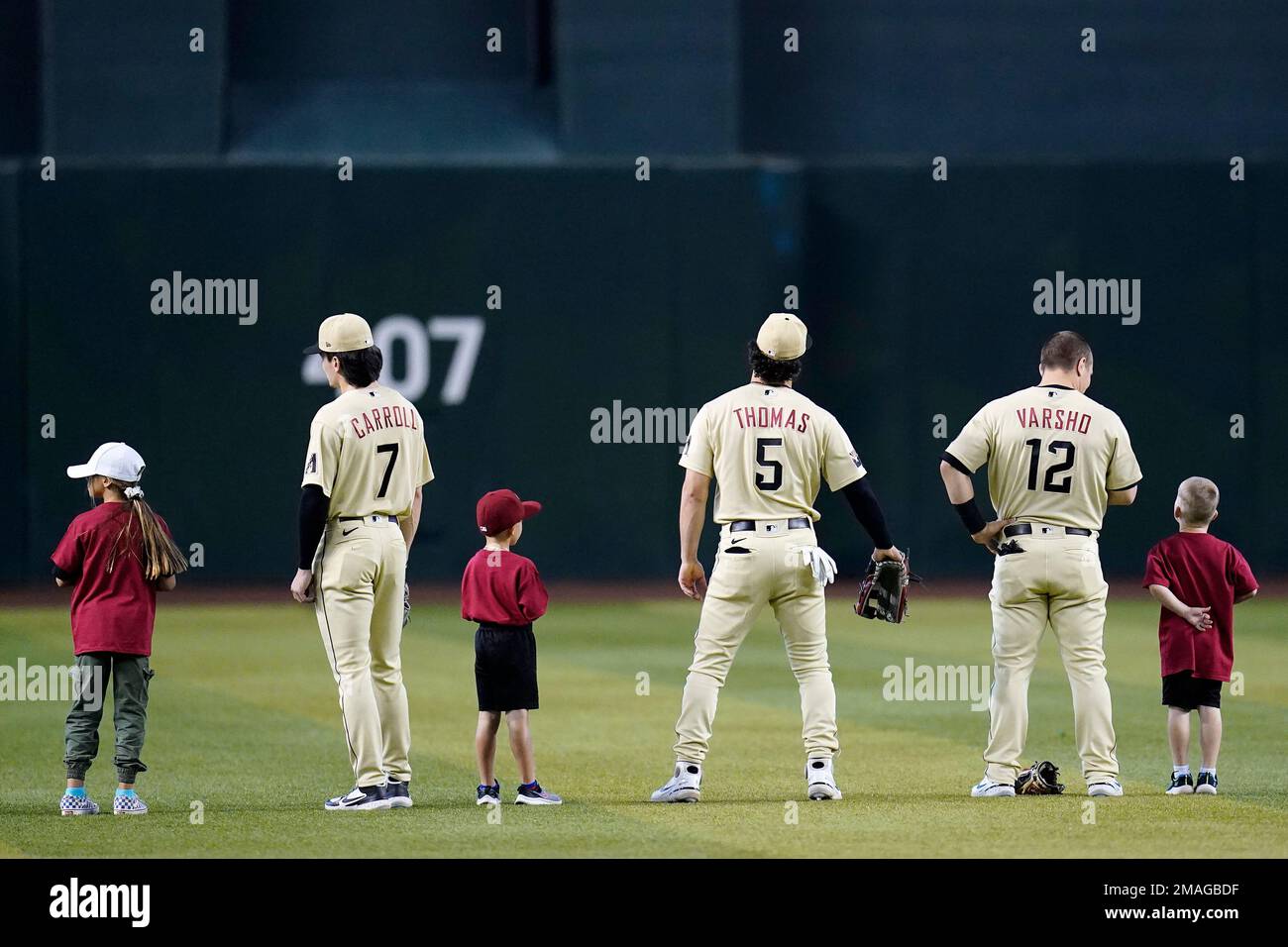 Arizona Diamondbacks' Corbin Carroll (7), Alek Thomas (5), and Daulton  Varsho (12) stand with kids in the outfield prior to a baseball game  against the San Diego Padres in Phoenix, Sunday, Sept.