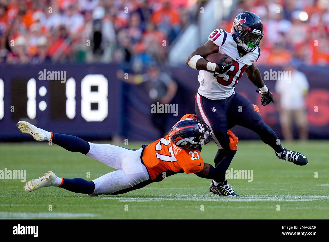 Houston Texans running back Dameon Pierce (31) is tripped up by Denver