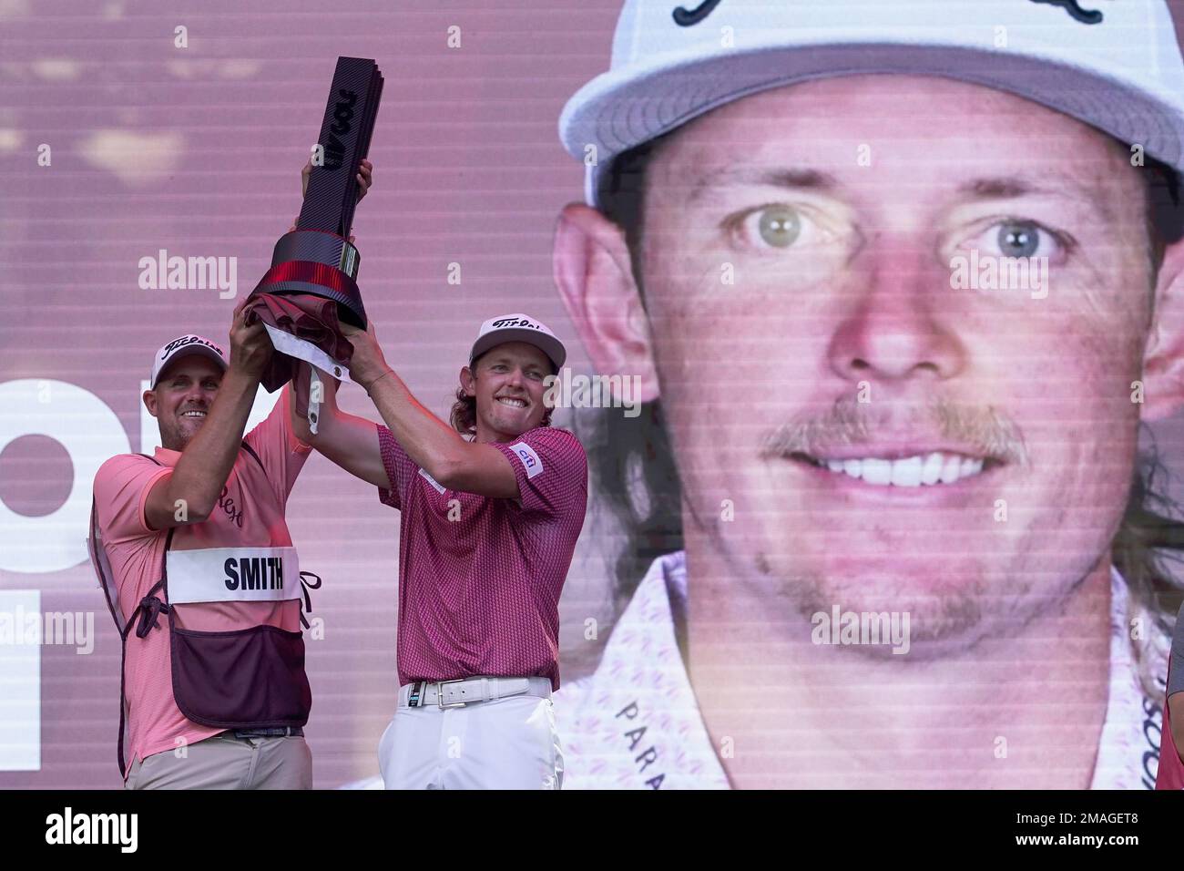 Cameron Smith and his caddie celebrate with the champion's trophy after