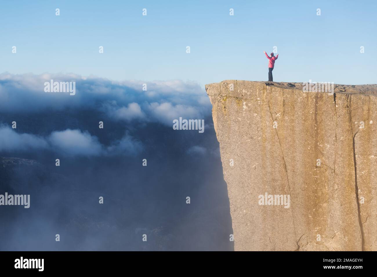 Preikestolen - amazing rock in Norway. Girl standing on a cliff above ...