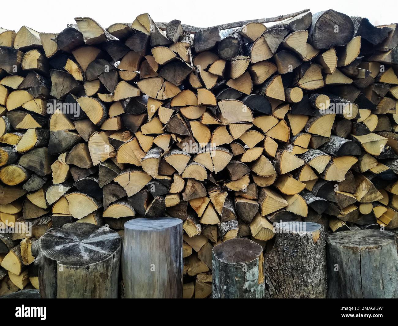 Chopped firewood is stacked in neat piles. Woodpile. Background. Close