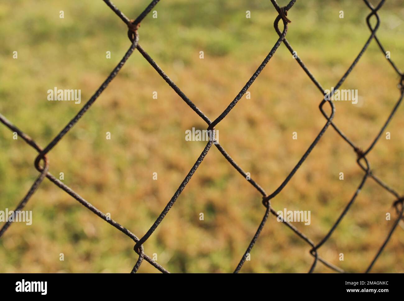 Rusty chain link fence outdoor nature field closeup shot Stock Photo