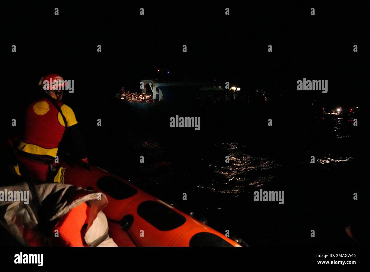A member of the Spanish NGO Open Arms stands on a boat as the migrants ...