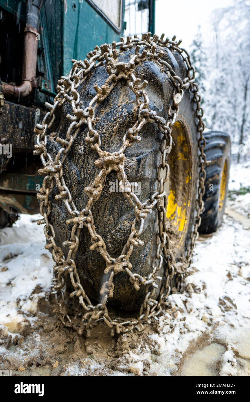 Closeup for extreme big off road 4x4 vehicle wheel with a snow and mud chains.. Extreme off