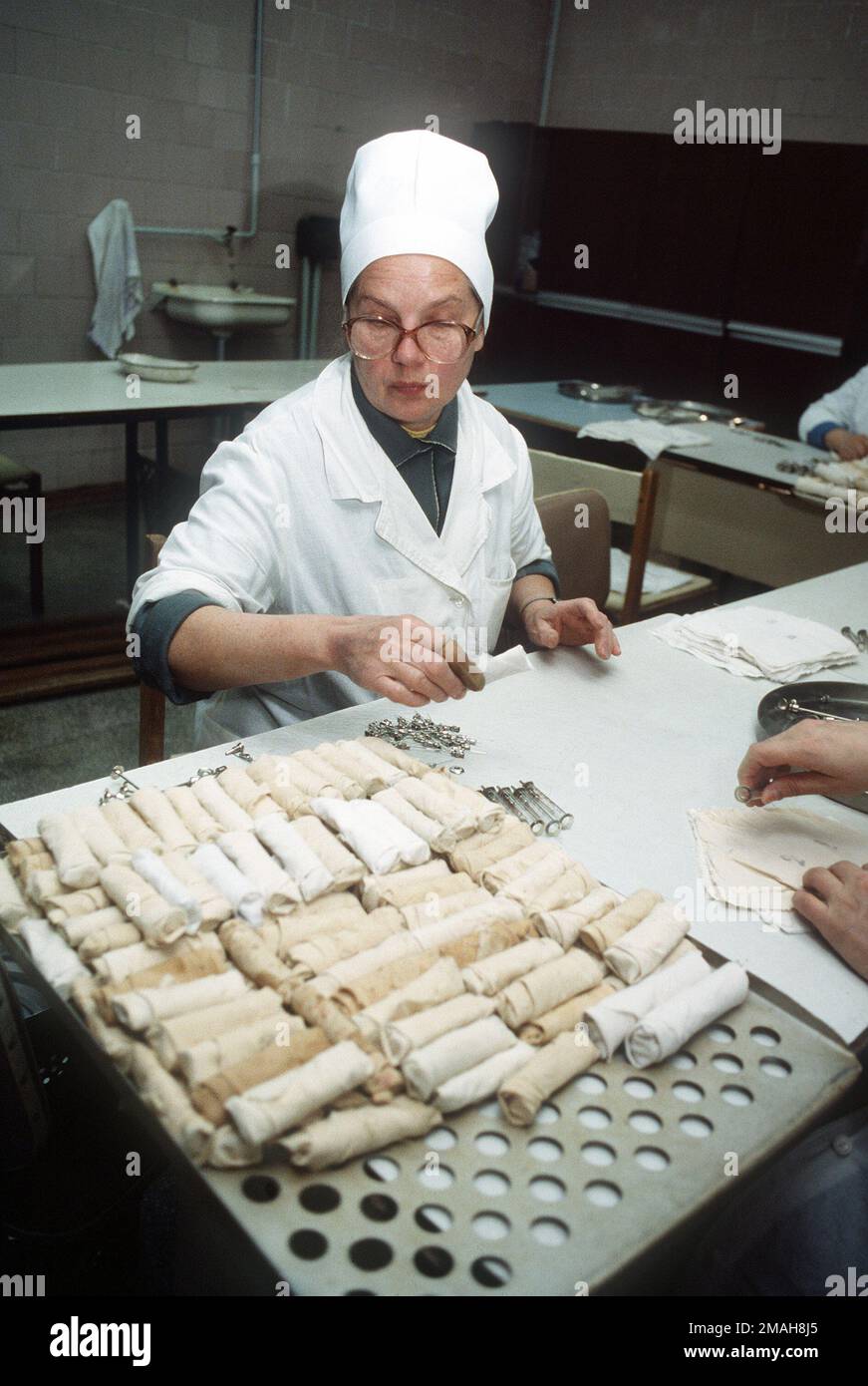 A nurse prepares needles and syringes for sterilization at a hospital
