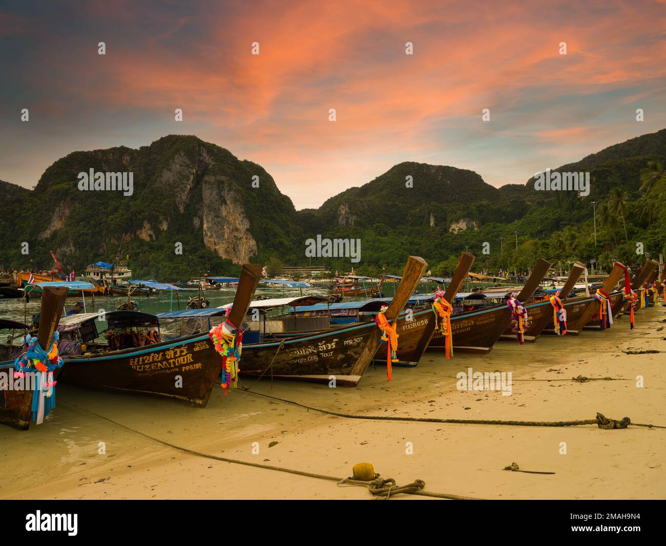 Phi Phi Island, Krabi, Thailand. December 2, 2022. The famous Ton Sai beach at sunset time. Traditional tour boats on the beach and beautiful bay view Stock Photo