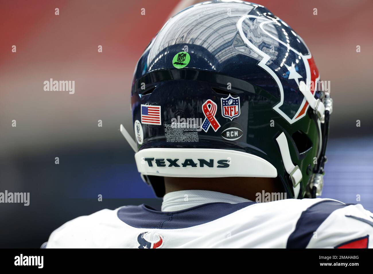 Houston Texans player seen from the back with the American flag, 9-11 and NFL  shield decals on his helmet during pregame warmups before an NFL football  game against the Indianapolis Colts on