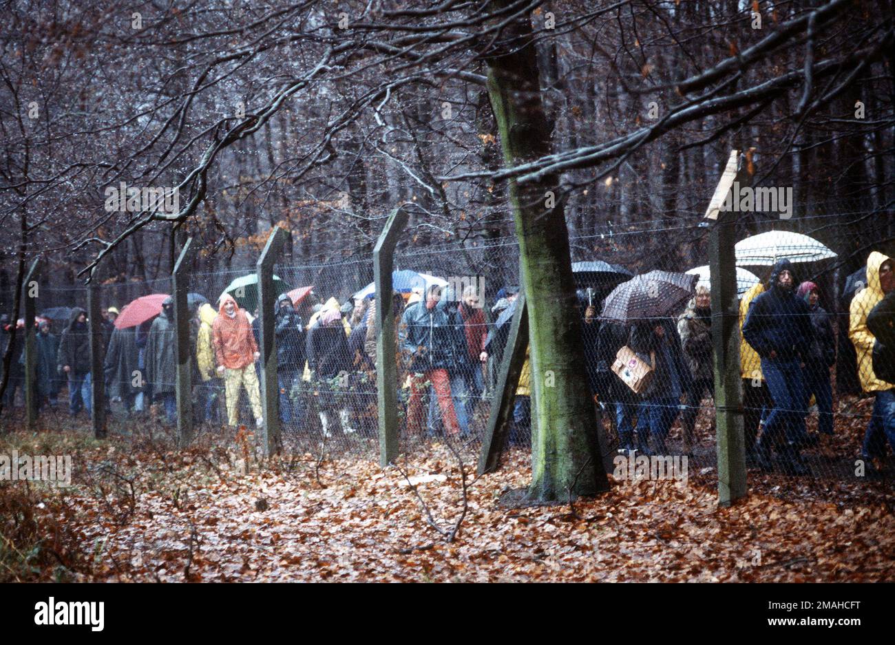 Protesters march in the rain outside the perimeter fence. The protesters were part of a group of approximately 300 who were demonstrating peacefully against NATO's decision to deploy Pershing II and cruise missiles in Western Europe. Base: Rhein-Main Air Base Country: Deutschland / Germany (DEU) Stock Photo