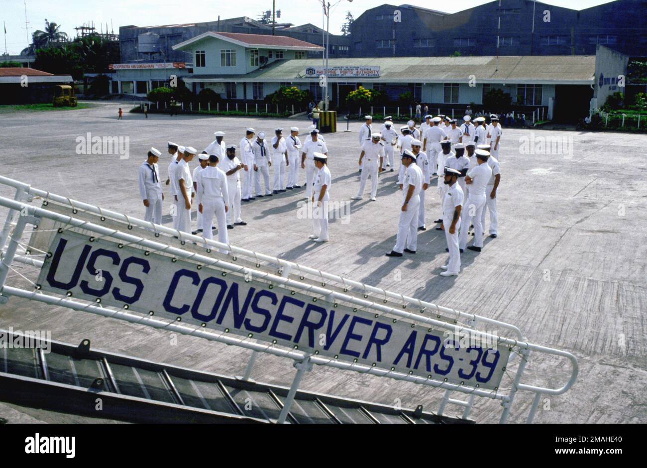 Crewmen from the salvage ship USS CONSERVER (ARS-39) stand on the pier next to their ship and prepare to march in a civil-military parade commemorating GEN Douglas MacArthur's return here 37 years ago. MacArthur's return fulfilled his earlier and oft-quoted promise of I shall return. Base: Leyte Island Country: Philippines (PHL) Stock Photo