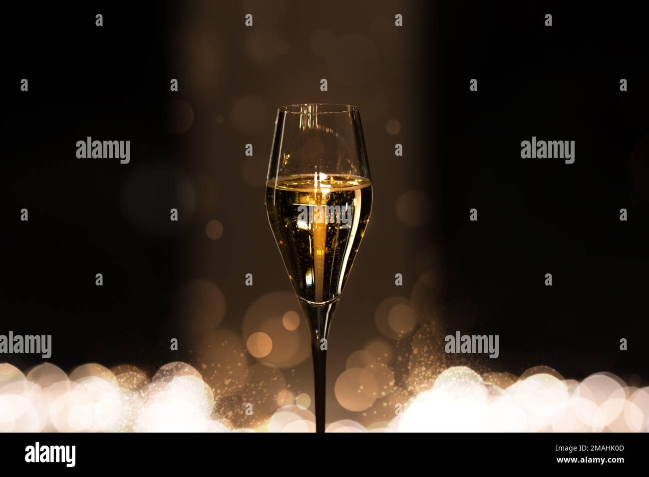 Glass of champagne with bubbles on dark background with bokeh. Celebration and party concept.  Stock Photo