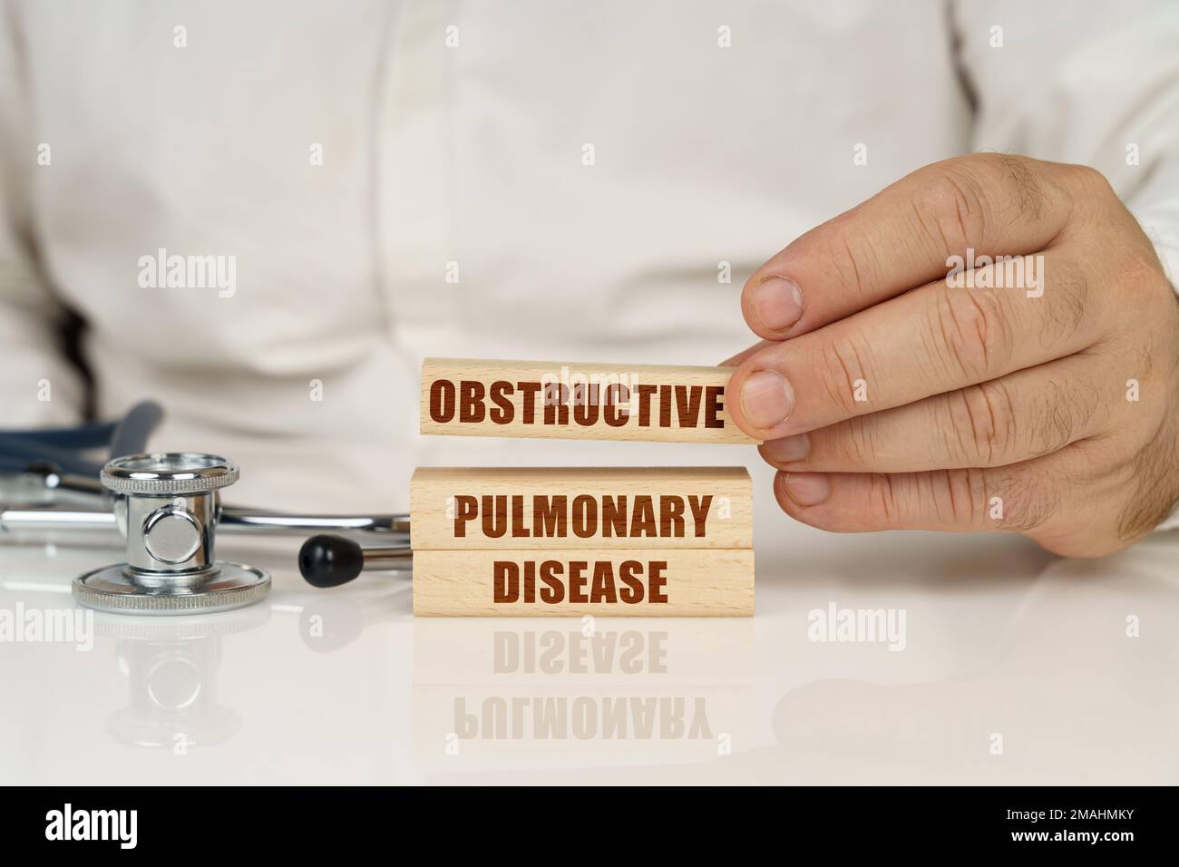 Medical concept. On a white surface, a stethoscope and wooden plates with the inscription - obstructive pulmonary disease Stock Photo