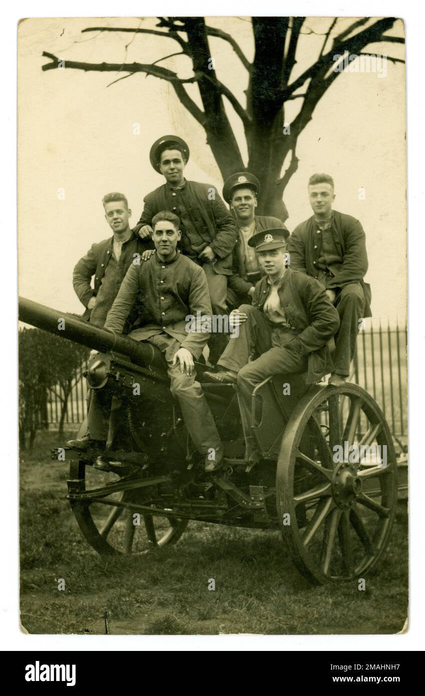 Original WW1 era postcard of a group of young men of the Royal Norfolk Regiment messing about on top of a field gun at a training camp. A rare photograph of young men about to be sent to the front, excited to be leaving home, before they know the horrors of the trenches. Cannon fodder. Circa 1916  U.K. Stock Photo