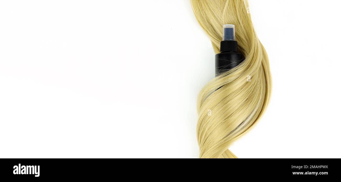 Different professional hairdresser tools hair spray and strand of blonde hair on white background, flat lay. Accessories for haircut with copy space Stock Photo