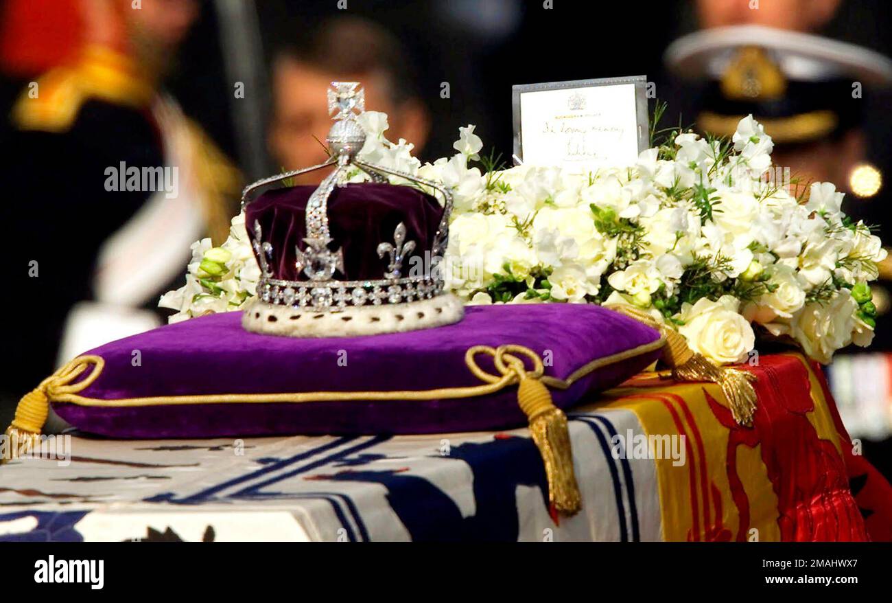 FILE - The Koh-i-noor, or "mountain of light," diamond, set in the Maltese Cross at the front of the crown made for Britain's late Queen Mother Elizabeth, is seen on her coffin, along with her personal standard, a wreath and a note from her daughter, Queen Elizabeth II, as it is drawn to London's Westminster Hall in this April 5, 2002. Hundreds of thousands of people are expected to flock to London’s medieval Westminster Hall from Wednesday, Sept. 14, 2022, to pay their respects to Queen Elizabeth II, whose coffin will lie in state for four days until her funeral on Monday. (AP Photo/Alastair  Stock Photo