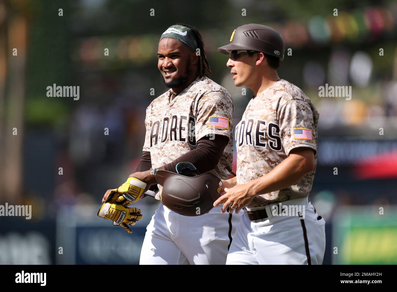 San Diego Padres' Eguy Rosario smiles as he hands first base coach David Macias his battling