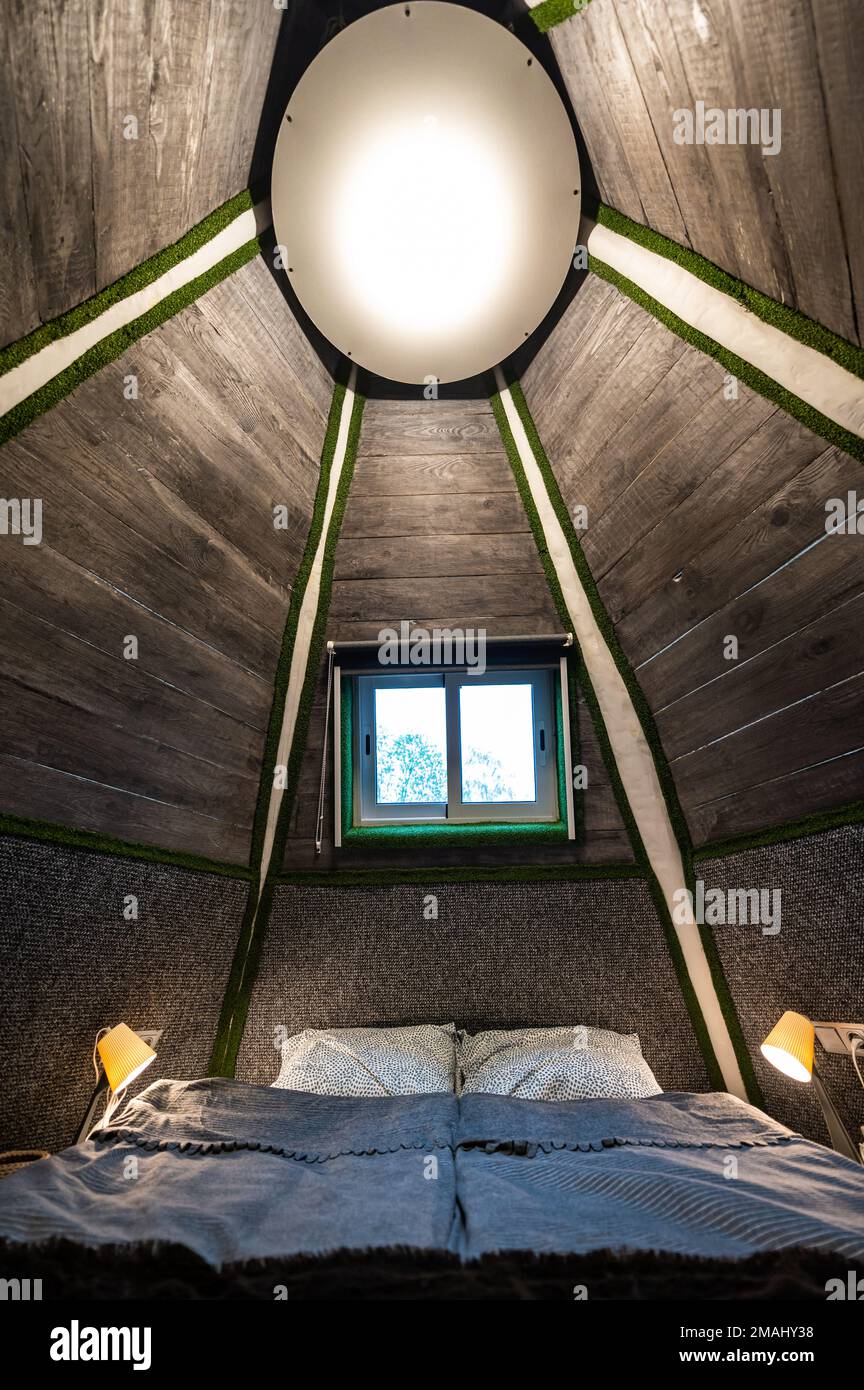 Double bed in bedroom of pyramid shape wooden cabin. Pyramid shape ...