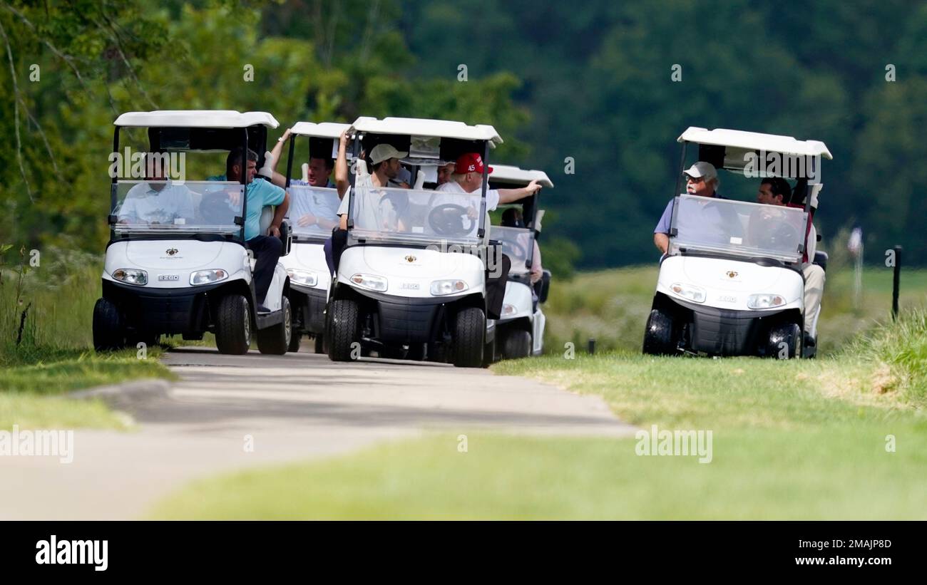Former President Donald Trump, center cart, rides around his golf ...